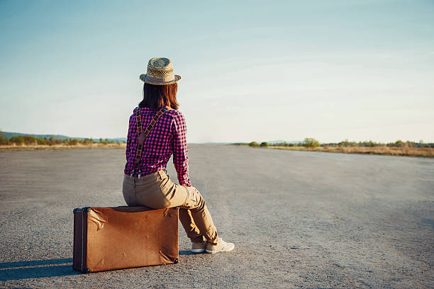 istock Traveler girl sits on suitcase 503402417
