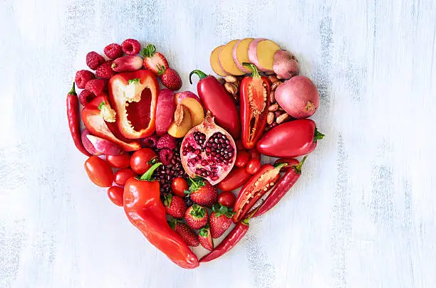 Photo of Red heart made from fresh raw fruits and vegetables