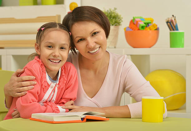 istock Daughter and mother reading the book 503413266