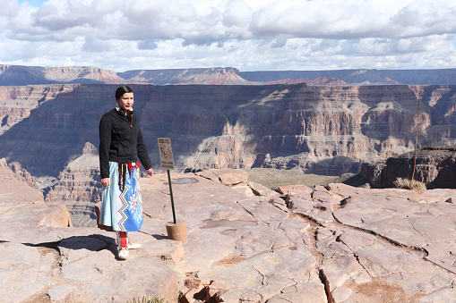 Grand Canyon, Arizona, Usa - January 31, 2008: Young Navajo Indian woman standing at the edge of Grand Canyon Western Rim