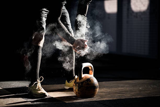 Gym fitness workout: Man ready to exercise with kettle bell Gym fitness workout: Man ready to exercise with kettle bell crossfit chalk weightlifting weight training stock pictures, royalty-free photos & images