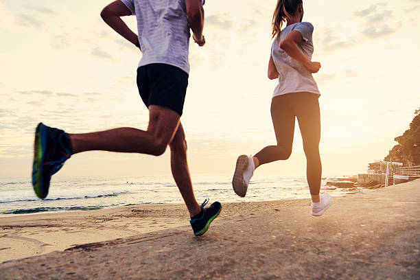 They keep each other moving Shot of people running along the beachhttp://195.154.178.81/DATA/i_collage/pu/shoots/806139.jpg sports training australia stock pictures, royalty-free photos & images