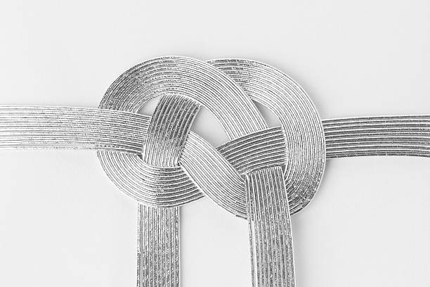 décoratif argent japonaise cordon de serrage en ruban sur le livre blanc. - chrome metal tied knot twisted photos et images de collection