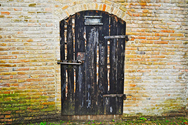 istock wooden door in a brick wall 503422186