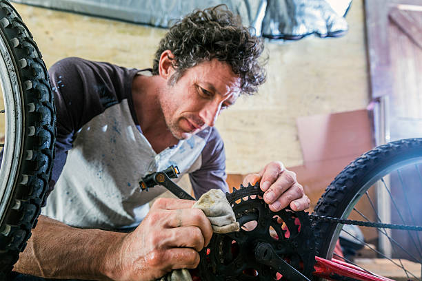 istock Mechanic cleaning bicycle gear with cloth 503424366