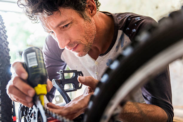 istock Concentrated mature mechanic oiling bicycle chain 503424514