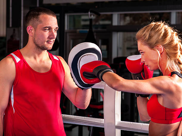 istock Female boxer  throwing  right cross at mitts 503425192