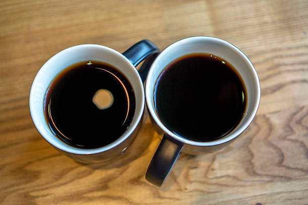 istock two cups of black coffee on wooden table 503425642