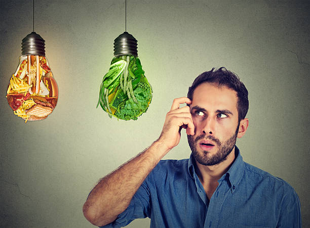 man thinking looking up at junk food green vegetables