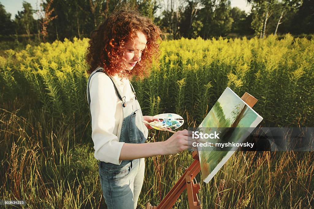 Young woman painting landscape in open air. Young woman painting landscape in the open air. Painting - Activity Stock Photo