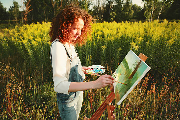 młoda kobieta malarstwo krajobraz w powietrzu. - painting artist landscape painted image zdjęcia i obrazy z banku zdjęć