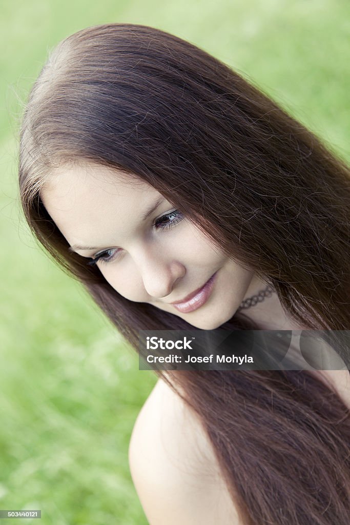 Dreamy and pensive Beautiful young woman is dreamy and pensive. She looks down and smiles slightly. 16-17 Years Stock Photo