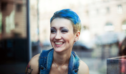 Pierced and tattooed young woman with blue hair