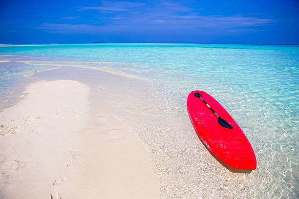 istock Red surfboard on white sandy beach with turquoise water 503452904