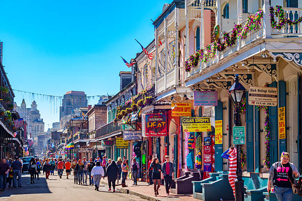 New Orleans Colorful French Quarter New Orleans, USA - February 7, 2015: People walk on colorful Bourbon Street in the French Quarter of New Orleans during the Mardi Gras festival. new orleans mardi gras stock pictures, royalty-free photos & images