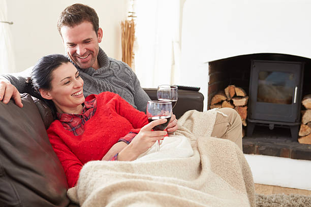 casal relaxar em casa beber vinho - cair no sofá imagens e fotografias de stock