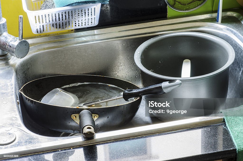 Dirty dishes in the sink Dirty dishes in the sink  pots and tableware ready to wash Chaos Stock Photo