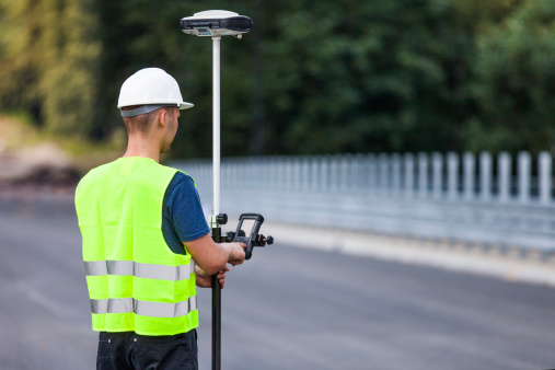 Land surveyor working with a GPS unit (Global Positioning System).