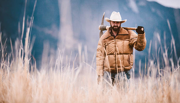 istock Man wearing cowboy hat holds pickaxe over shoulder 503457077