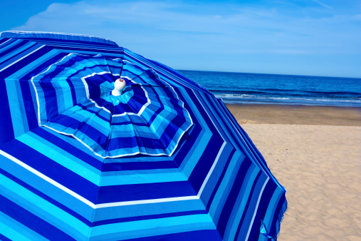 Empty beach with beach umbrella on a sunny day