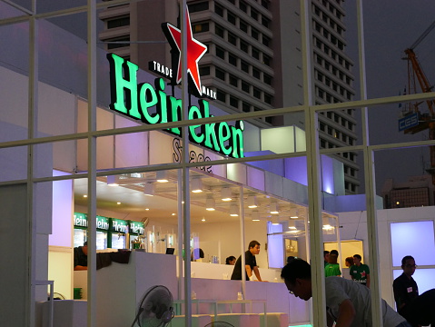 Bangkok, Thailand – December 10, 2015: View of Heineken Beer Garden in front of the Central World Shopping Mall in Bangkok. People are in the area. Some staff prepare the service to welcome customers. 