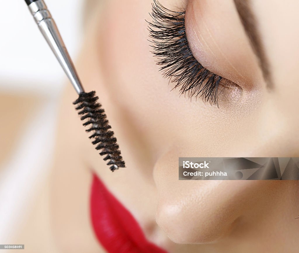 Woman eye with beautiful makeup and long eyelashes. Mascara Brus Woman eye with beautiful makeup and long eyelashes. Mascara Brush. Applying Stock Photo