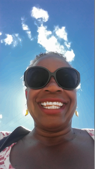 Selfie Series - Smiling mature African American woman with sun shining behind her