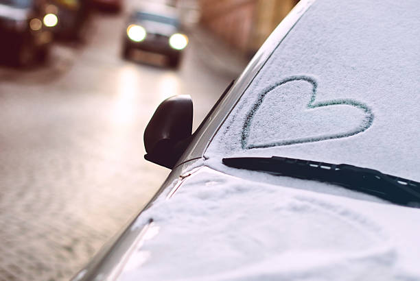 Drawn heart on a car windscreen Heart drawn on a car windscreen covered with snow. valentines day holiday photos stock pictures, royalty-free photos & images