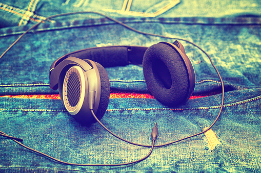 large wired headphones on the background of jeans