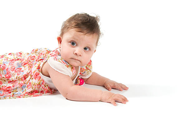 portrait d'une petite fille allongée sur le sol. - newborn little girls baby lying down photos et images de collection