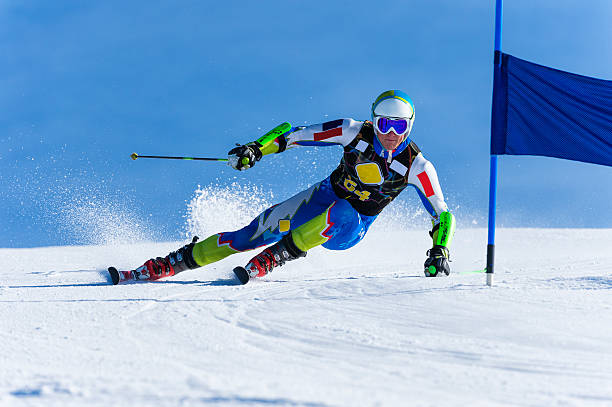 Young Man Compeeting at Giant Slalom Race Front view of young skier at giant slalom race; at the blue gate alpine skiing stock pictures, royalty-free photos & images