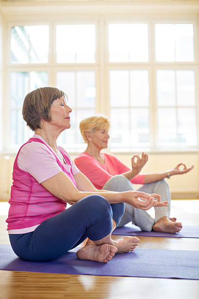 istock Senior women meditating at yoga class 503468042