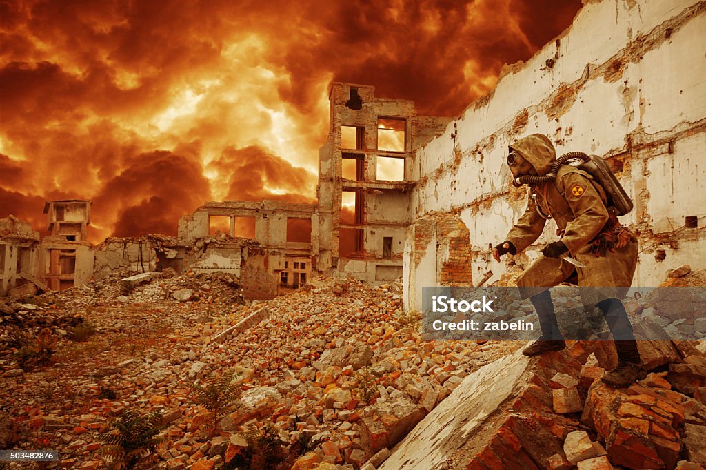 Nuclear apocalypse survivor Post apocalypse. Sole survivor in tatters and gas mask on the ruins of the destroyed city  War Stock Photo