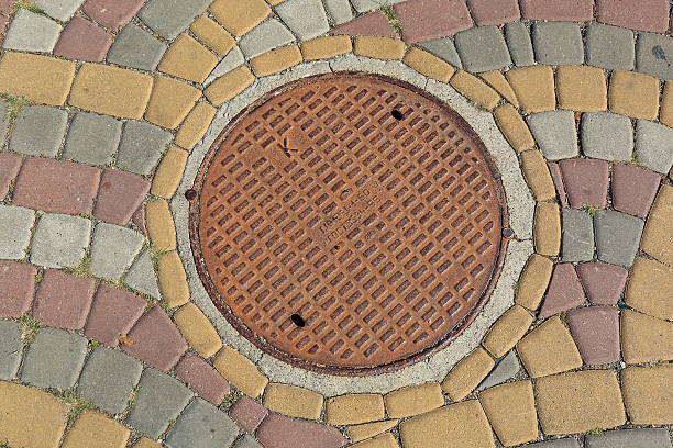 Pyatigorsk, Russia - October 4, 2015: Rusty metal manhole cover in a pavement from colored blocks