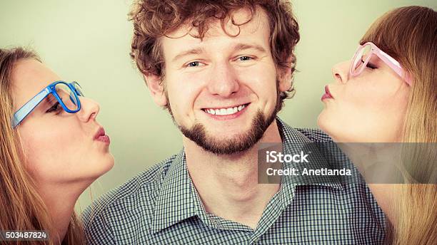 Two Pretty Young Women Kissing Handsome Man Stock Photo - Download Image Now - Adult, Beautiful People, Beauty