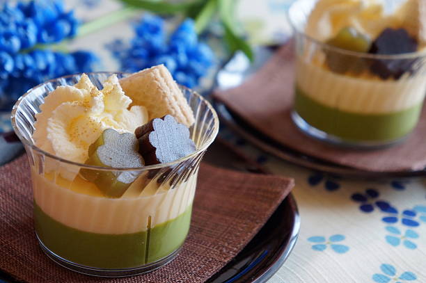 Green tea mousse and white chocolate mousse with whipped cream and golden powder.Modern Japanese style dessert.