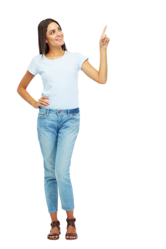 Full length shot of an attractive young woman pointing upward isolated on white