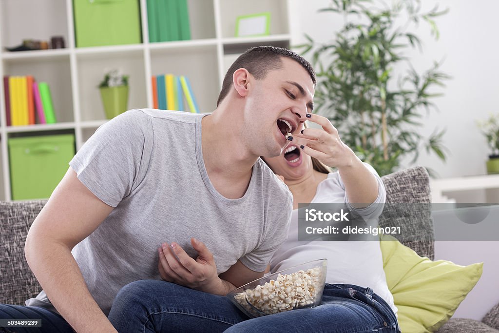 Girl feeding her boyfreind Girl feeding her boyfreind with popcorn Adult Stock Photo