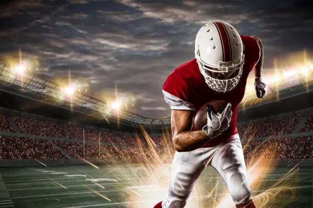 Football Player with a red uniform running on a stadium.