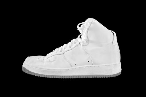 A high-top classic white leather basketball shoe sneaker isolated on black
