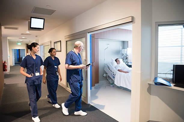 personal médico en hospital pasillo con el paciente en la cama - patient room fotografías e imágenes de stock