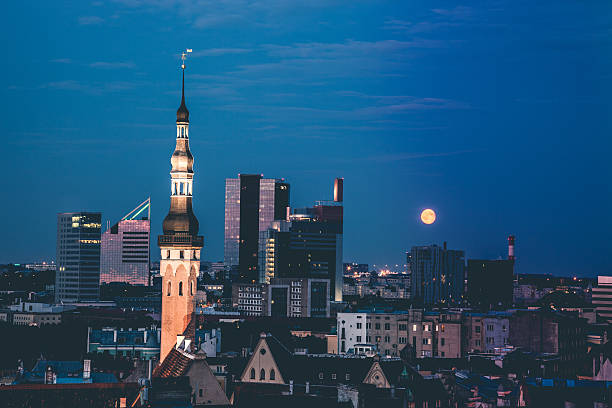 Tallinn at dusk with a beautiful moon on the background of modern city.