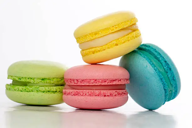 Photo of Collection of brightly colored French macarons on white backgrou