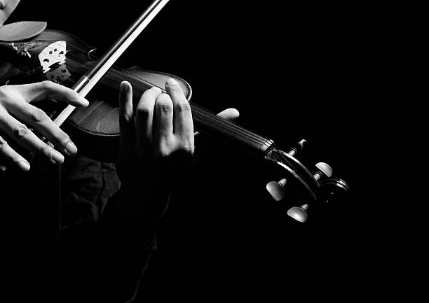 istock male violinist hands playing classical violin, isolated on black 503507846