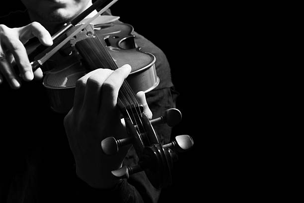 istock male violinist hands playing classical violin, isolated on black 503507952