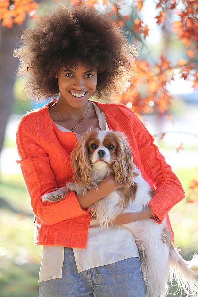 istock young black lady smiling and showing her dog 503509612