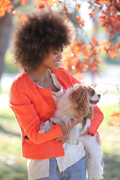 istock young black lady smiling and showing her dog 503509640