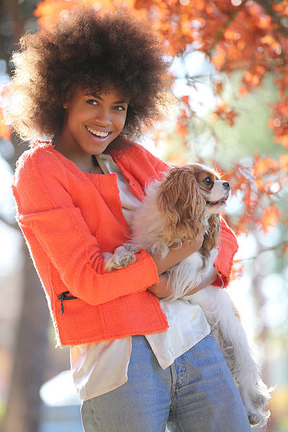 istock young black lady smiling and showing her dog 503509670