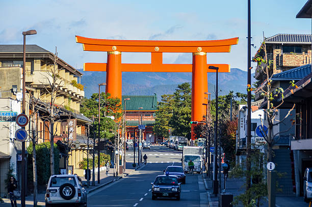 Kyoto, Japan - November 27, 2015: Heian Shrine was built in 1895 for the 1,100th anniversary of the Establishment of Kyoto. A giant torii gate marks the approach to the shrine, around which there are a couple of smaller shrines. The actual shrine grounds themselves are very spacious, with a wide open court at the center. The shrine's main buildings are a partial replica of the original Imperial Palace from the Heian Period, built on a somewhat smaller scale than the original.
