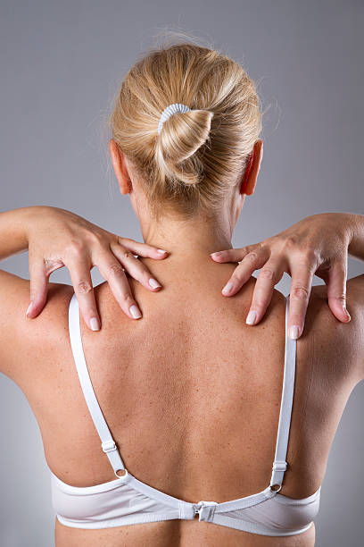femme avec douleurs au niveau des épaules. douleur dans le corps humain - massaging massage therapist rear view human hand photos et images de collection